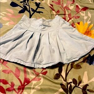 Light blue cheer style pleated miniskirt with back zip and button
